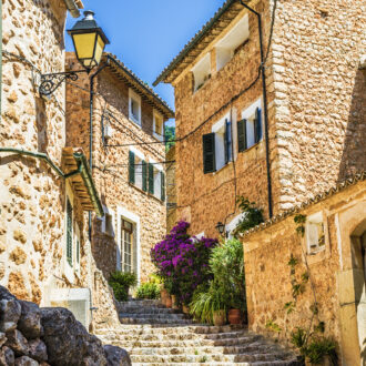 Stone‑paved street in Fornalutx with Tramuntana mountain backdrop