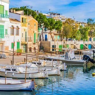 Fishing boats and colorful houses along Portocolom’s waterfront.