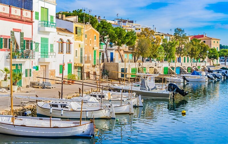 Fishing boats and colorful houses along Portocolom’s waterfront.