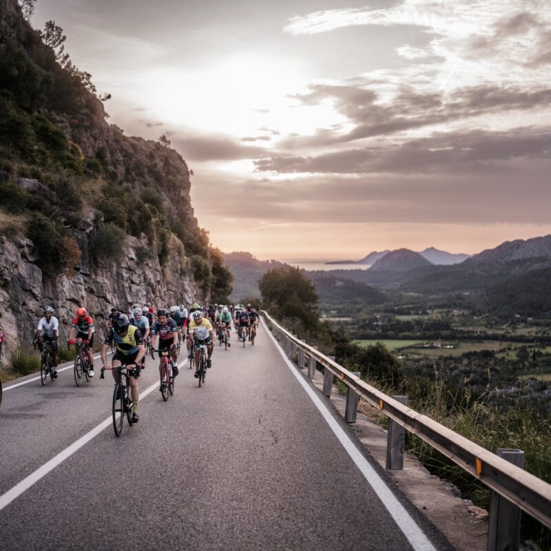 Cyclist climbing towards Lluc Monastery through the Tramuntana mountains in Mallorca.