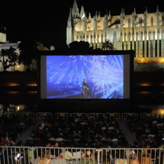 Outdoor movie screening at Parc de la Mar with Palma Cathedral illuminated at night